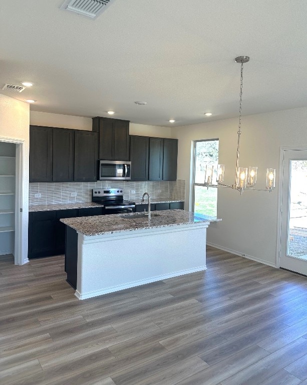 kitchen featuring stainless steel appliances, visible vents, a sink, and tasteful backsplash