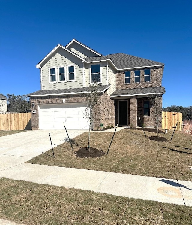 traditional home with driveway, brick siding, an attached garage, and fence