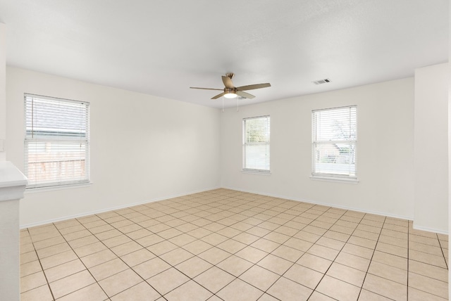 tiled spare room with ceiling fan