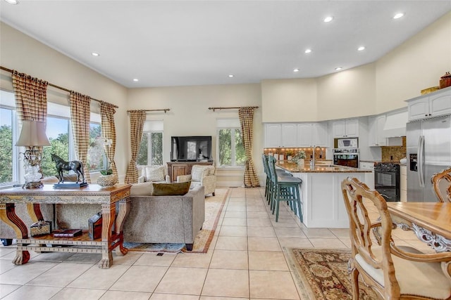 13628 Gregg Manor Rd, Manor, TX 78653 - living area with light tile patterned flooring, recessed lighting, and a towering ceiling