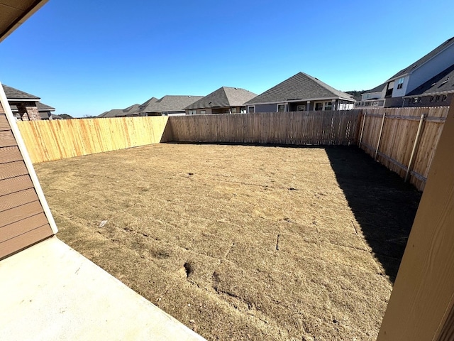 view of yard with a fenced backyard and a residential view