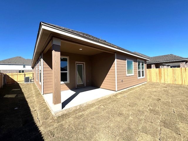 rear view of property featuring fence, cooling unit, and a patio