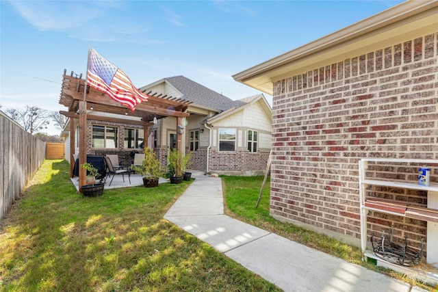 entrance to property with a patio area, a lawn, and a pergola