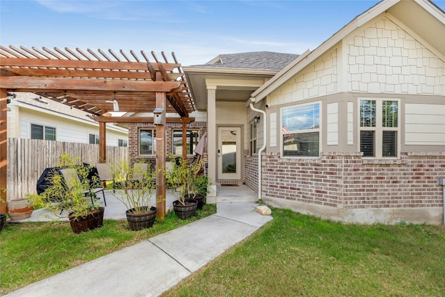 view of exterior entry with a pergola, a patio area, and a lawn