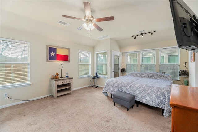 bedroom featuring ceiling fan, light colored carpet, multiple windows, and vaulted ceiling