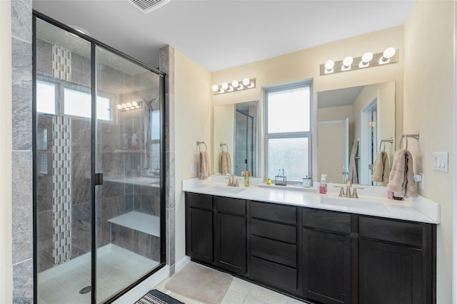 bathroom with a wealth of natural light, a shower with door, tile patterned floors, and vanity