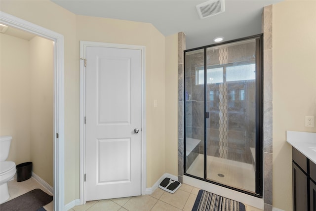 bathroom featuring toilet, tile patterned flooring, a shower with shower door, and vanity