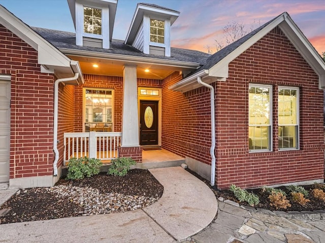 exterior entry at dusk with covered porch