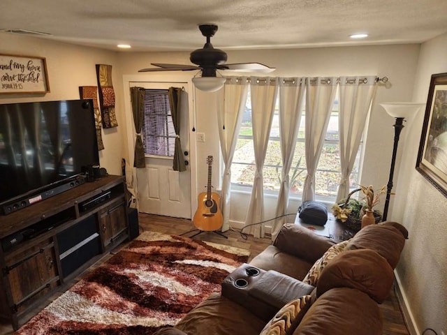 living room featuring ceiling fan and dark hardwood / wood-style flooring