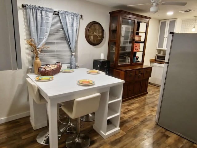 dining room with ceiling fan and dark wood-type flooring