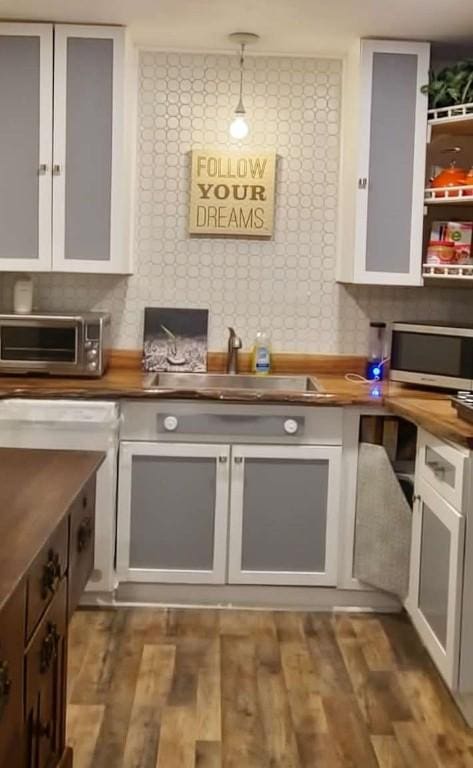 kitchen featuring decorative light fixtures, butcher block countertops, white cabinetry, and dark hardwood / wood-style floors