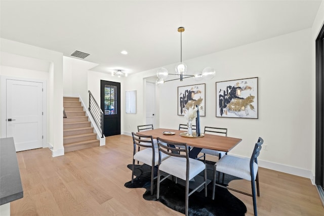 dining area featuring a chandelier and light wood-type flooring