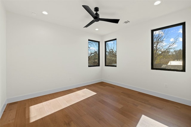 empty room with hardwood / wood-style floors and ceiling fan