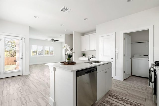 kitchen with a center island with sink, sink, appliances with stainless steel finishes, white cabinetry, and washer / clothes dryer