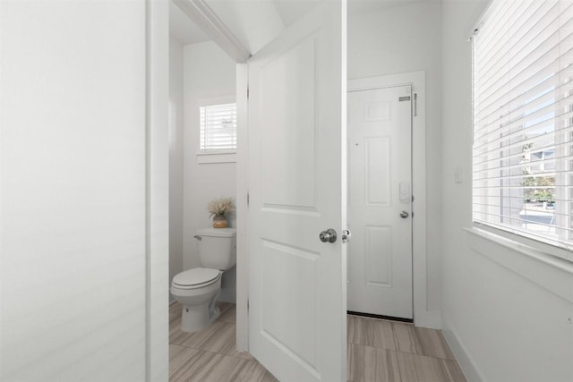 bathroom with plenty of natural light and toilet