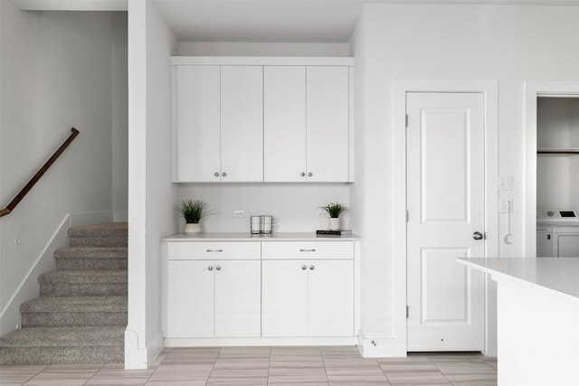 bar featuring white cabinets, light tile patterned floors, and washer / clothes dryer