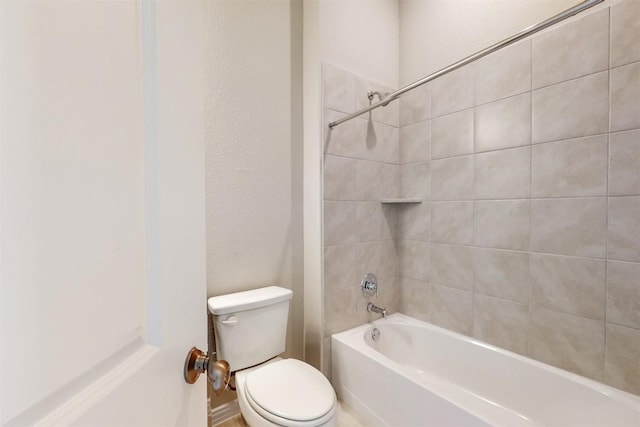 bathroom featuring toilet and tiled shower / bath