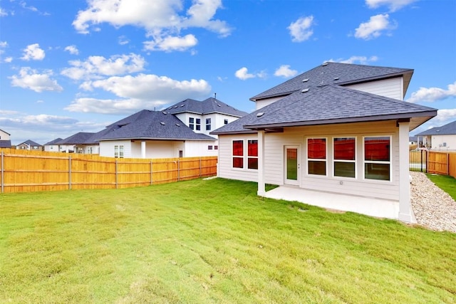 rear view of house with a lawn and a patio