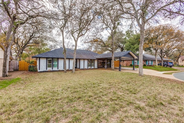 ranch-style home featuring a front yard and a carport