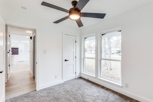 unfurnished bedroom featuring ceiling fan and light colored carpet