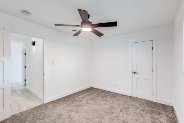 carpeted spare room featuring ceiling fan