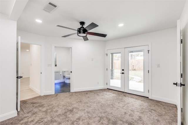 interior space with access to outside, french doors, ensuite bath, ceiling fan, and light colored carpet