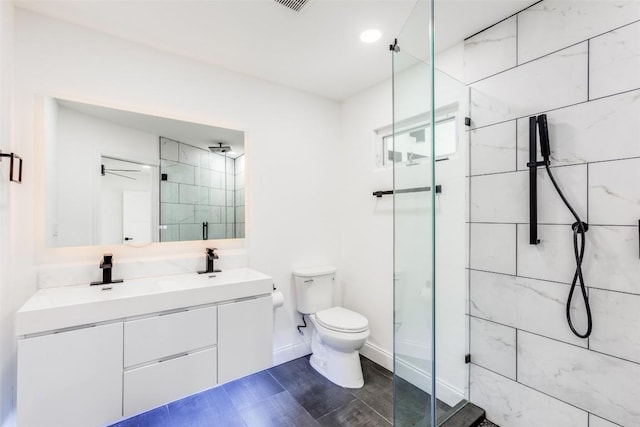 bathroom featuring vanity, toilet, a shower with door, and ceiling fan