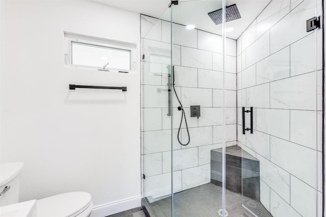 bathroom featuring toilet and a shower with door