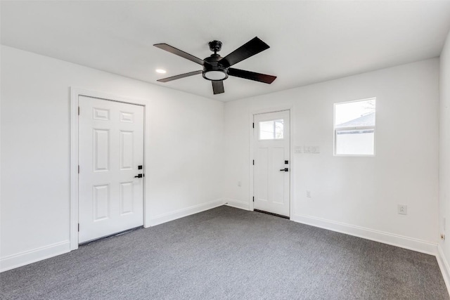 spare room with dark colored carpet and ceiling fan