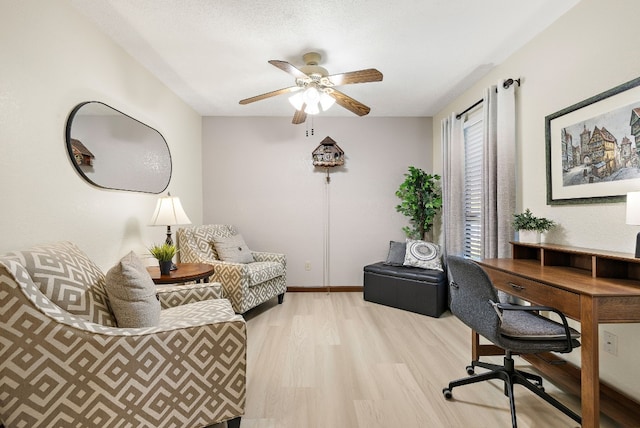 office with a textured ceiling, light wood-type flooring, and ceiling fan