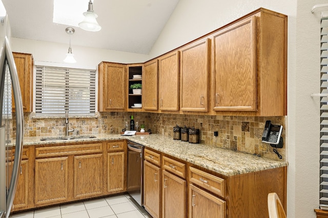 kitchen with pendant lighting, sink, vaulted ceiling, light stone countertops, and stainless steel appliances