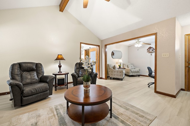 living room featuring lofted ceiling with beams, ceiling fan, and light hardwood / wood-style flooring