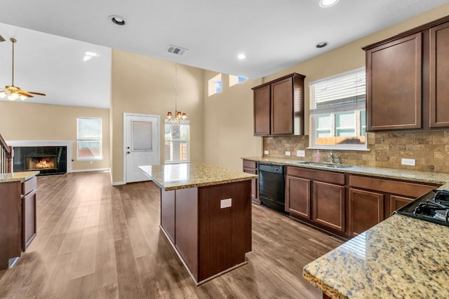 kitchen with dishwasher, a center island, decorative light fixtures, and a fireplace