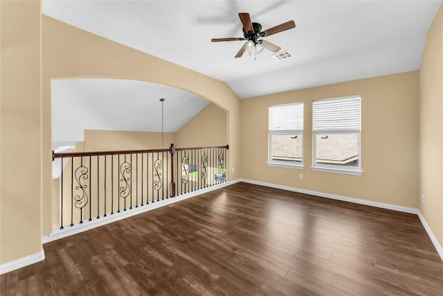 spare room with dark hardwood / wood-style floors, vaulted ceiling, and ceiling fan