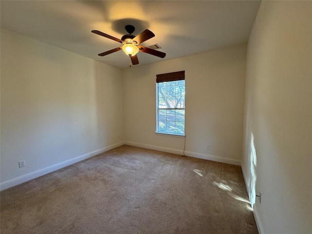 carpeted spare room featuring ceiling fan