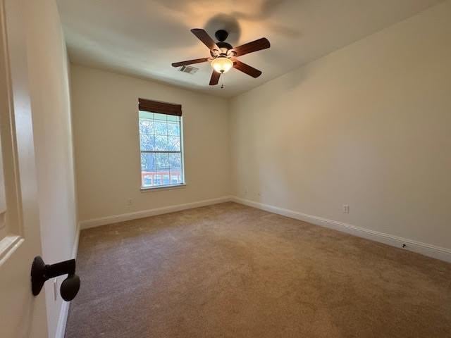 carpeted spare room featuring ceiling fan