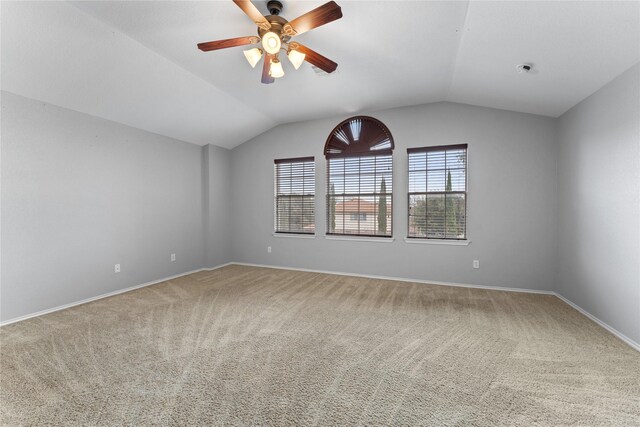 empty room featuring carpet flooring, ceiling fan, and lofted ceiling