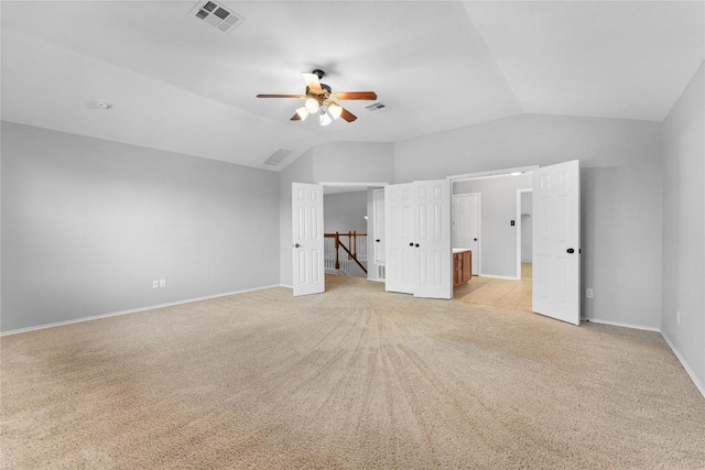 unfurnished bedroom with light carpet, vaulted ceiling, and ceiling fan