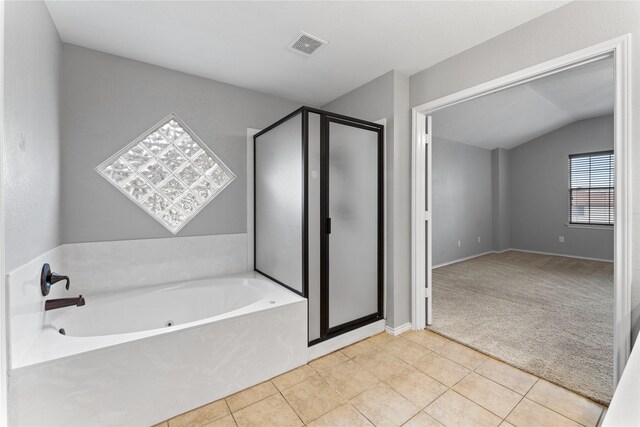 bathroom with tile patterned floors, separate shower and tub, and lofted ceiling