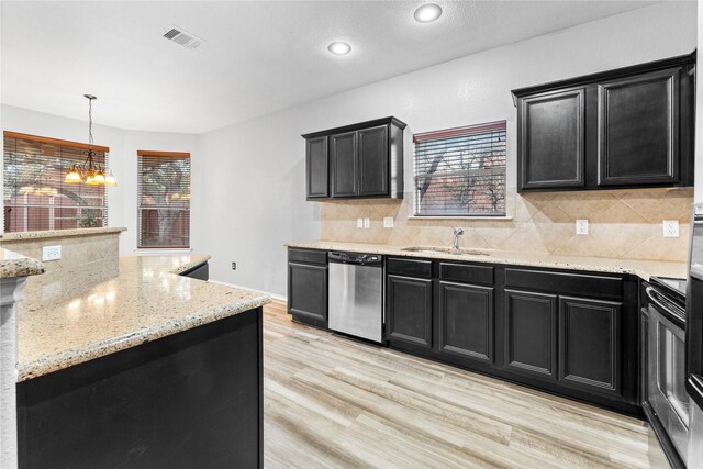 kitchen with sink, hanging light fixtures, stainless steel dishwasher, light hardwood / wood-style floors, and a chandelier