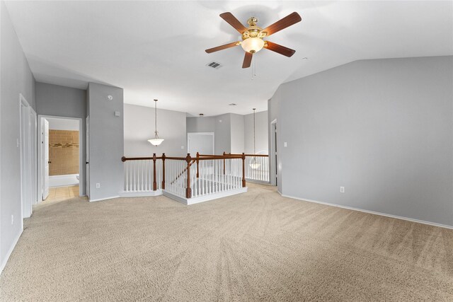 unfurnished room with ceiling fan, light colored carpet, and lofted ceiling