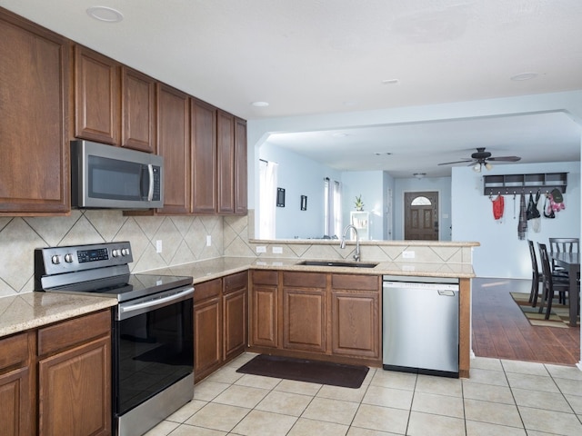 12400 Tay Ter, Austin, TX 78754 - kitchen with appliances with stainless steel finishes, a sink, a peninsula, and tasteful backsplash