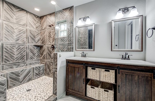 bathroom with a tile shower and vanity