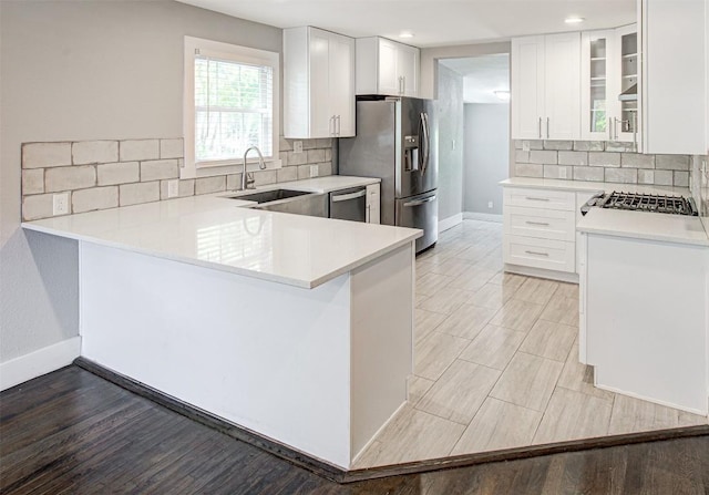 kitchen featuring kitchen peninsula, white cabinets, and appliances with stainless steel finishes