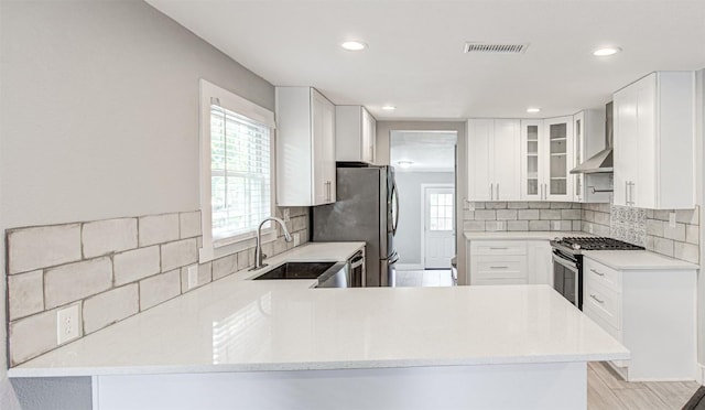 kitchen with white cabinets, kitchen peninsula, sink, and appliances with stainless steel finishes