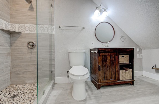 bathroom with a tile shower, lofted ceiling, and toilet