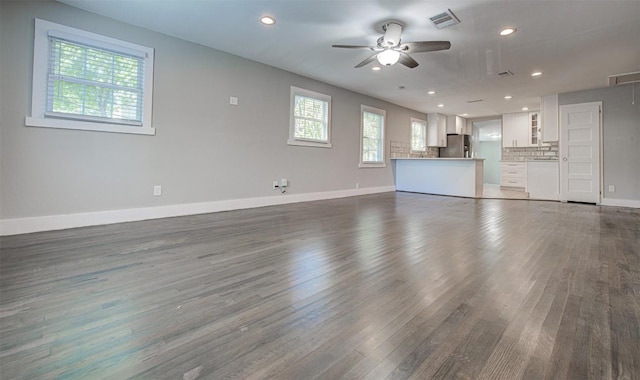 unfurnished living room with ceiling fan and dark wood-type flooring