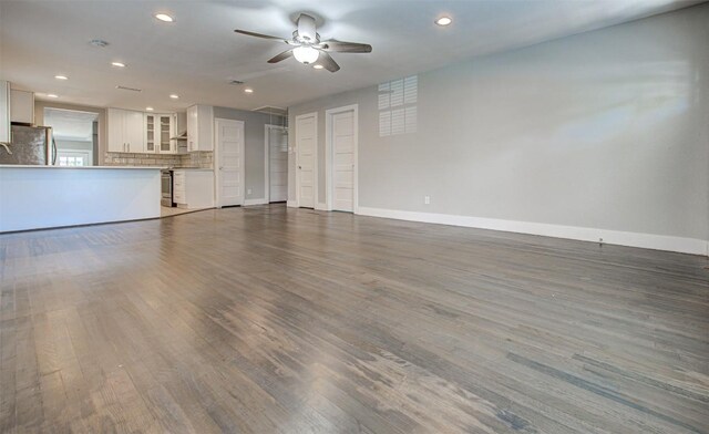 unfurnished living room featuring ceiling fan and dark hardwood / wood-style flooring