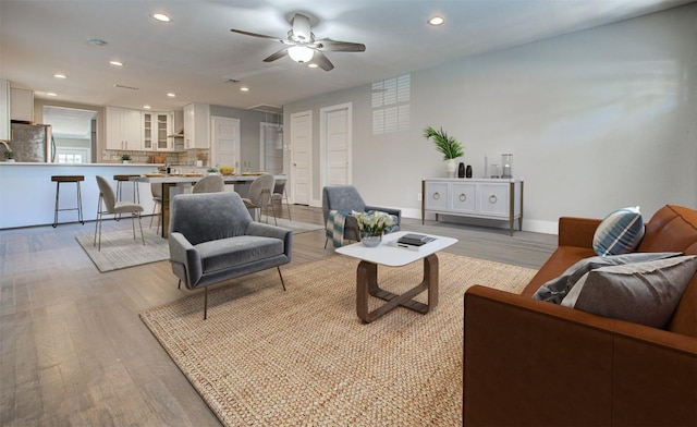 living room featuring light hardwood / wood-style floors and ceiling fan