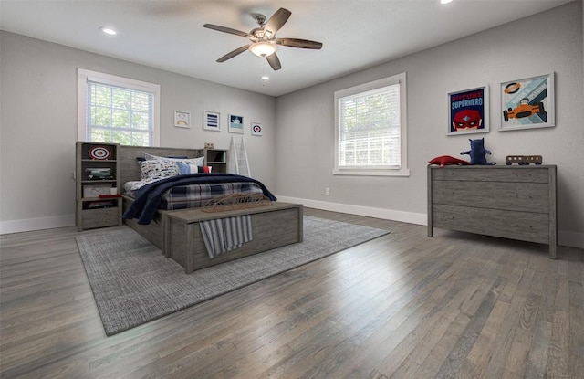 bedroom with multiple windows, ceiling fan, and dark wood-type flooring